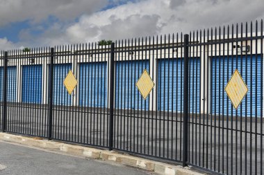 STANTON, CALIFORNIA - 17 SEPT 2023: Bir depo tesisini çevreleyen siyah işlemeli demir çit.