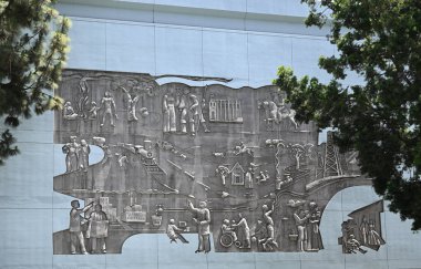 LOS ANGELES, CALIFORNIA - 19 Mayıs 2025: The Evolution of Los Angeles, Los Angeles şehir merkezindeki Broadway 'e bakan bir otoparkta inşa edilmiş beton yardım heykeli..
