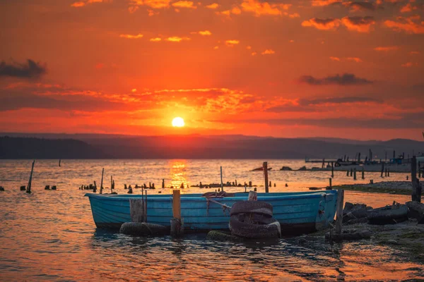 木製の桟橋と古い漁船の上の夕日 — ストック写真