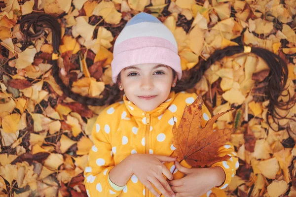 Красивая Маленькая Девочка Играет Опавших Цветных Осенних Листьях Парке Гинкго — стоковое фото