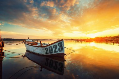 2023 mutlu yıllar konsepti. Varna Gölü 'nde gün batımında suda bir yansımayla balıkçı teknesi. Doğa manzarası.
