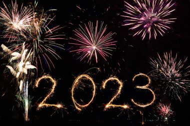 2023 Mutlu Yıllar Parıltılı Havai fişekler 'in kara gece gökyüzü metni. Havai fişekler ve aydınlatma kutlaması.