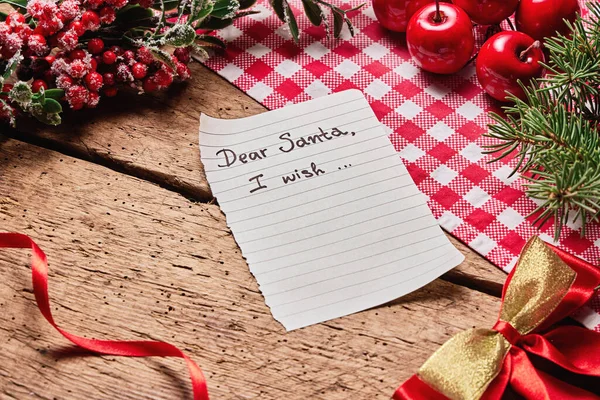 Dear Santa Claus wish card and letter on wooden desk with many colorful Christmas and new year decoration