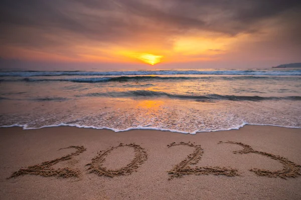 Happy New Year 2023 concept for travel, lifestyle, sport, meditation. 2023 text lettering on the ocean beach sand at sunrise. Sea Sunset of 2022. Punta Cana, Bavaro, Dominican Republic