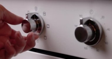 Turning oven on and rotate the buttons for temperature and minutes 4K video, starting baking in oven. 