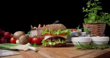 Healthy appetizing beef burger with keto gluten free bun, onion, fresh vegetables, melted cheese, lettuce and sauce. Hamburger, food background 4k fhd video