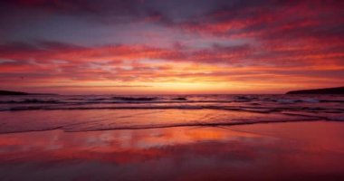 Color sunrise over ocean waves and beach shore. Tropical island 4K video of seascape view
