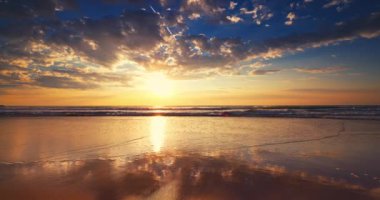 Beautiful color sunrise over tropical island beach,  sea waves and sandy shore, Cinematic video in 4k 