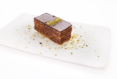 Chocolate cake with walnuts and pistachio isolated on white background. Pastry from homemade bakery