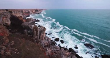 Bulgaristan manzarası, Karadeniz kıyısı deniz manzarası. Kamen Bryag 'daki kayalık kayalıklar ve çarpan dalgalar panoramik manzara, dramatik 4k video