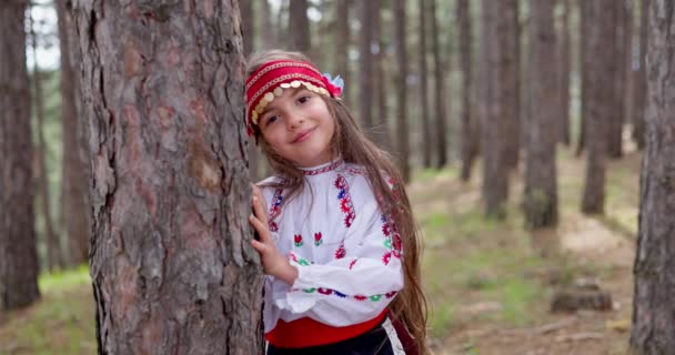 Χαρούμενη Χαμογελαστή Βουλγάρα Παραδοσιακή Φορεσιά Που Κρύβεται Πίσω Από Δασικό — Αρχείο Βίντεο