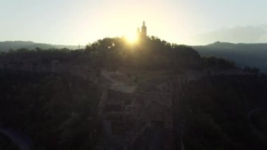 Aerial sunrise view of Tsarevets Fortress in Veliko Tarnovo city in a beautiful summer day, Bulgaria nature and history, 4k aerial video