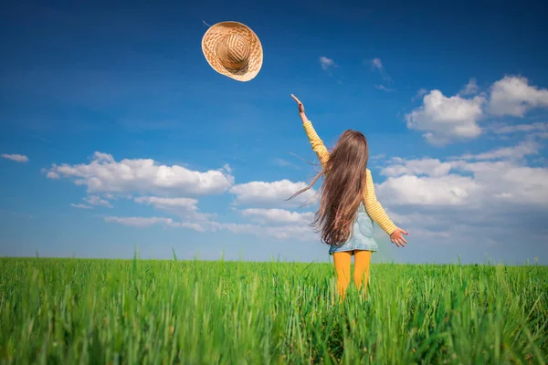 緑小麦畑の風景と幸せな農家の女の子プレイとともにわら帽子 — ストック写真