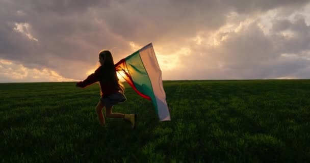 保加利亚农村 一个年轻的爱国女孩 日落时分 在绿地上飘扬着牛群的旗帜 视频4K — 图库视频影像