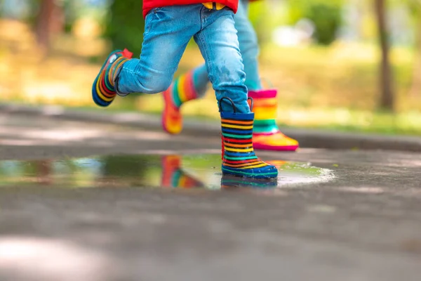 Gyermek Lába Színes Gumicsizmában Átugrik Esős Pocsolyán Egy Parkban — Stock Fotó