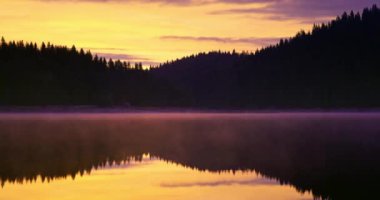 Göl suyu ve yeşil orman çam ağaçları üzerinde mistik bir gün doğumu. Baraj Shiroka polyana (Geniş çayır) Rodopi dağlı doğa manzarası. Bulgaristan