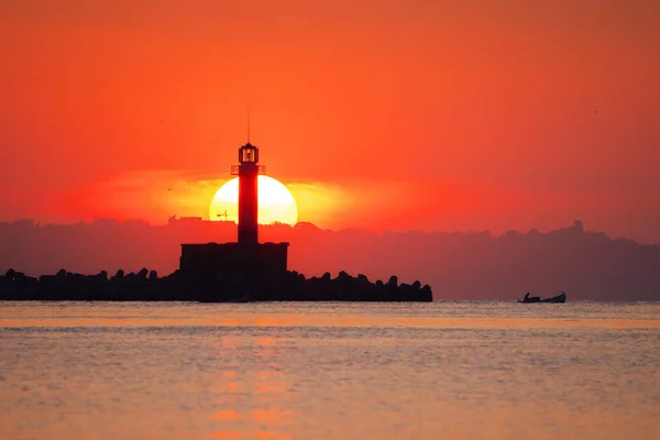 Seascape of sunrise over sea lighthouse and coastal beach shore, Varna, Bulgaria