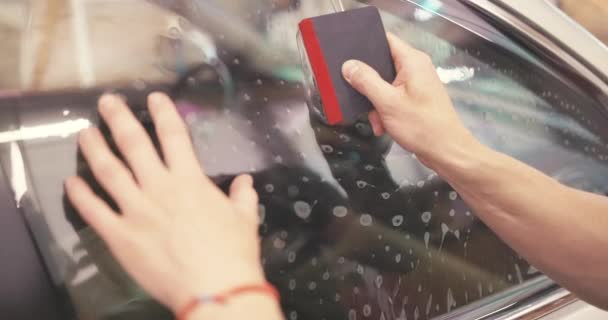 車の着色窓 車の窓にテント箔を適用する労働者の専門家4Kビデオ — ストック動画