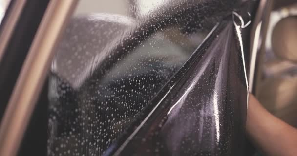 車の着色窓 車の窓にテント箔を適用する労働者の専門家4Kビデオ — ストック動画