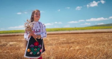 Bulgar nakışlı geleneksel etnik folklor kostümlü kız Bulgaristan 'da bir hasat altın buğday tarlasında duruyor