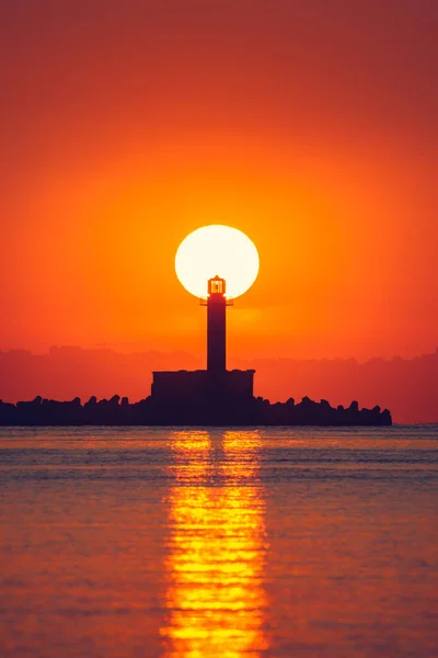 Seascape of sunrise over sea lighthouse and coastal beach shore, Varna, Bulgaria