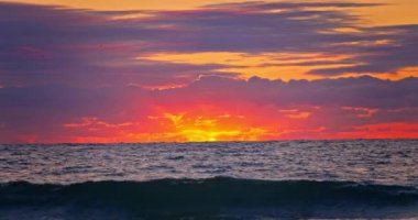 Dalgalı deniz dalgaları üzerinde manzaralı bulutlu renkli tropikal gün doğumu, okyanus batımı