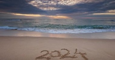 Sahil kıyısında sabah, metin 2024 Kumsalda ve manzaralı deniz gündoğumunda mutlu yıllar.