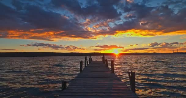 海の湖と小さな古い釣り桟橋の上の夕日 ストック映像