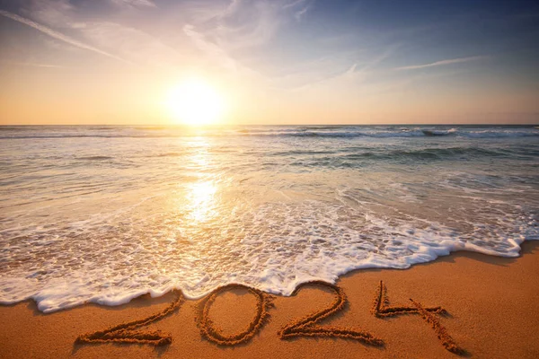 stock image Happy New Year 2024 concept, lettering on the beach. Written text on the sea beach at sunrise.