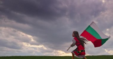 Bulgar kız standardı taşıyan etnik folklor kostümü içinde yeşil alanda koşan Bulgar bayrağı ve Bulgaristan 'ın 3 Mart Kurtuluş Günü' nü kutluyor