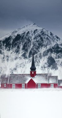Karlı kıyı zirveleri ve eski kızıl kilise Norveç 'in İskandinav kış manzarası, dikey video