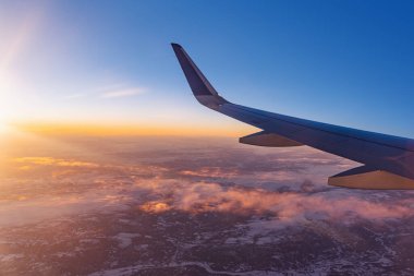 Karlı dağların üzerinde alçaktan uçan ve havaalanına inmeye hazırlanan uçak, kanat türbininin uçak penceresinden ve ufuk çizgisinden görüş