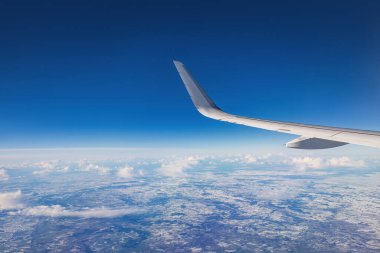 Renkli gökyüzü bulutları üzerinde uçan uçak manzaralı günbatımı veya gündoğumu bulutları, kanat türbinlerinin uçak penceresinden ve ufuk çizgisinden manzara