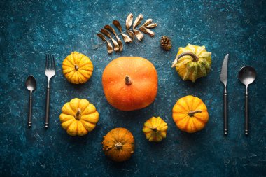 Mutfak çatalı, bıçak, kaşık ve çatal ile mavi vintage fon üzerinde sonbahar balkabağı. Şükran Günü Arkaplanı