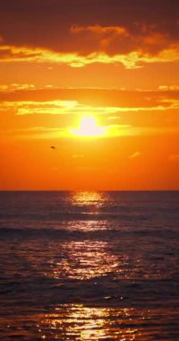 Sakin deniz dalgaları üzerinde altın yaz gündoğumu. Egzotik okyanus batımı dikey doğa videosu