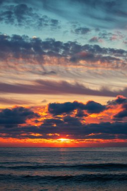 Denizin üzerinde güzel bulutlar, güneşin doğuşu dikey çekim