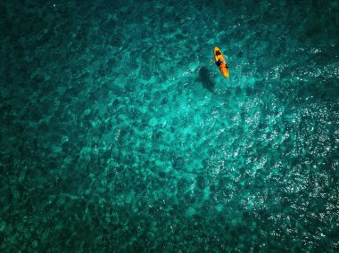 Aerial View of Solo Kayaker in Vibrant Blue Ocean Water clipart