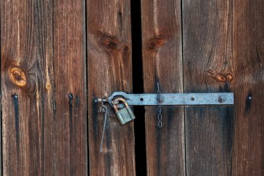 Paslı demir kilidi olan eski ahşap kırsal kapı.