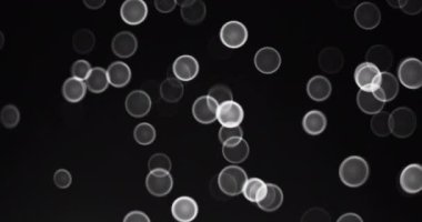 Kara Arkaplan videosundaki Soyut Kar ve Beyaz Bokeh Çemberleri