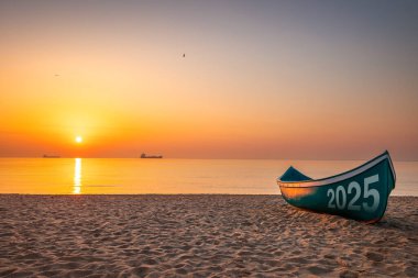 2025 yeni yıl teknesi gün doğumunda deniz kıyısında.