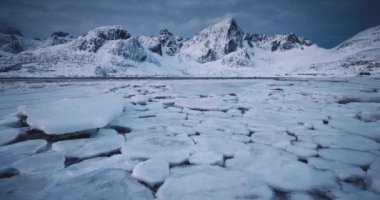 Kuzey Kutup Kış Manzarası Karla kaplı Dağ Zirvesi ve buzlu plaj ve deniz suyu, Lofoten Adaları, Norveç, Nordland