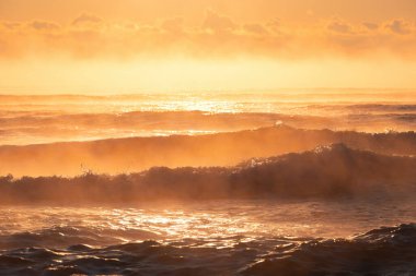 Sabah sisi ve güneş ışığıyla deniz dalgaları üzerinde güzel bulutlar.