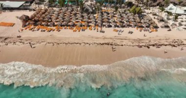 Tropik tatil beldesi Bavaro, Punta Cana, Dominik Cumhuriyeti 'nin hava manzarası, Karayip Denizi üzerinde gün doğumu, şemsiyeli kıyı şeridi, dinlenme yerleri, otel havuzları ve villaları.