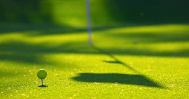 Golf sahasında yeşil çimenler, bayrak direği, delik, güneşli bir günde golf topu. Tropik ada Dominik Cumhuriyeti 'nde golf