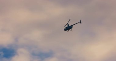Beyaz bulutlar, turizm turları, seyahat ve ulaşım ile mavi gökyüzünde yükseklerde uçan helikopter.