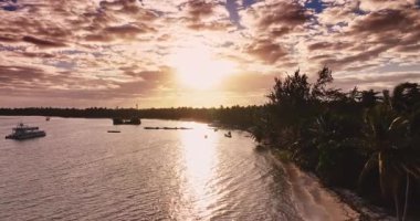 Tropikal ada sahili üzerinde canlı gündoğumu manzaralı günbatımı palmiye ağaçları lagünü, denizde yansıma ve ahşap iskele punta cana Dominik Cumhuriyeti yakınlarındaki katamaran tekneleri 