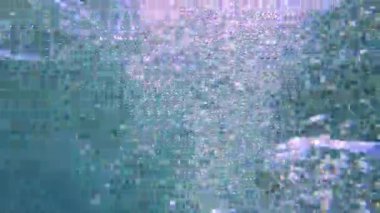 Okyanus yüzeyinde hava kabarcıkları ve ışık ışınlarıyla sualtı görüntüsü