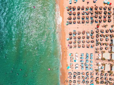 Şemsiyeli, güneşli ve kristal berrak turkuaz mavi deniz suyuyla kıyı sahili manzarası, Yunanistan adalarında yaz tatili