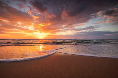 Sahildeki dalgalara yakın ve denizin üzerinde güzel bir gün doğumu