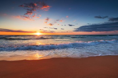 Deniz ufkunda ve sahil kıyısında güzel bir gün doğumu.